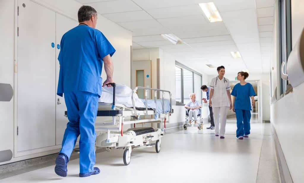 Doctor pushing patient on a patient stretcher in a hospital