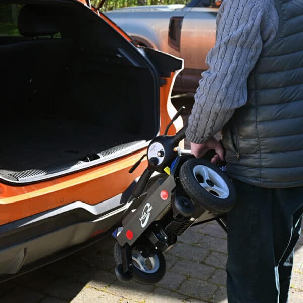 Man lifting Mirage folding mobility scooter into car boot