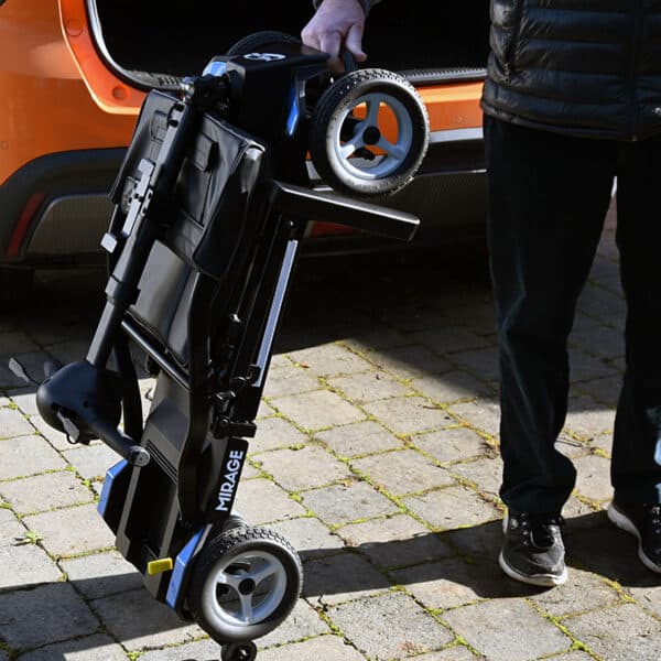 Man holding Mirage folding mobility scooter ready to put in car boot